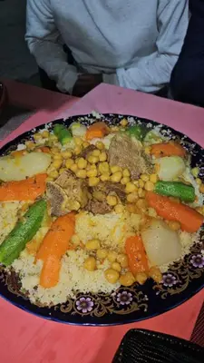 a plate of food with meat and vegetables on a table at Hôtel des cedres azrou in Oulad Akkou