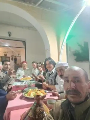 a group of people sitting at a table eating food at Hôtel des cedres azrou in Oulad Akkou