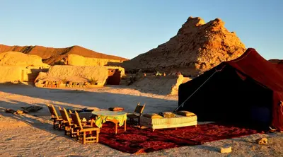 a tent in the desert with a table and chairs at Campement Akka Nait Sidi - Tissint in Tissint