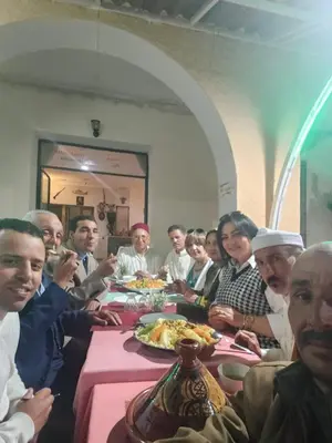 a group of people sitting at a table eating food at Hôtel des cedres azrou in Oulad Akkou