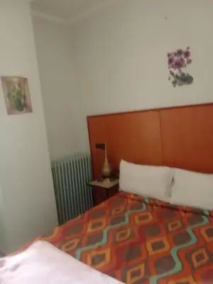 a bedroom with a bed with a wooden head board at Hôtel des cedres azrou in Oulad Akkou