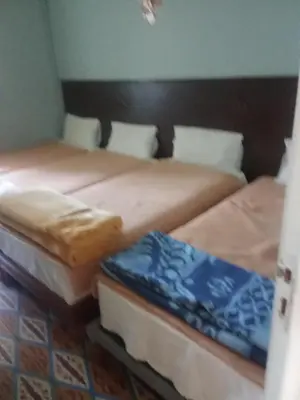 two beds sitting next to each other in a room at Hôtel des cedres azrou in Oulad Akkou