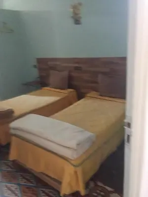 a room with three beds in a room at Hôtel des cedres azrou in Oulad Akkou
