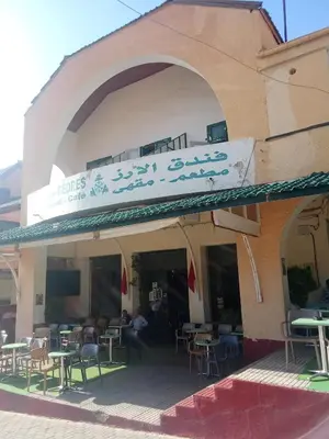 a restaurant with tables and chairs on a building at Hôtel des cedres azrou in Oulad Akkou