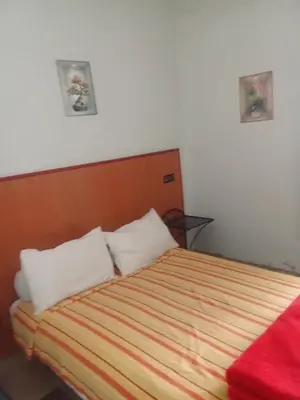 a bedroom with a bed with two pillows at Hôtel des cedres azrou in Oulad Akkou