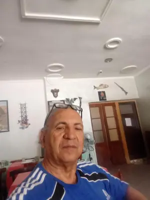 an older man is sitting in a room at Hôtel des cedres azrou in Oulad Akkou