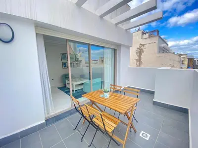 a dining room with a table and chairs on a balcony at Superbe appart central in Oulad Akkou