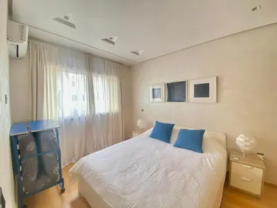 a bedroom with a bed with blue pillows and a television at Superbe appart central in Oulad Akkou