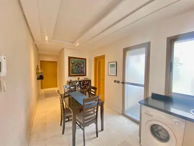 a dining room with a table and chairs and a washing machine at Superbe appart central in Oulad Akkou