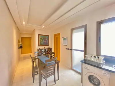 a dining room with a table and a washing machine at Superbe appart central in Oulad Akkou