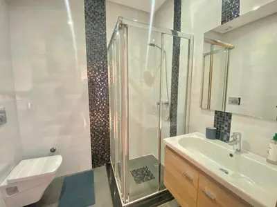 a bathroom with a shower and a toilet and a sink at Superbe appart central in Oulad Akkou