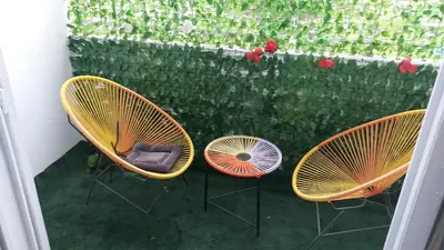 three chairs and a table and a fence with flowers at 2bedroom Apartments in Downtown in Fès