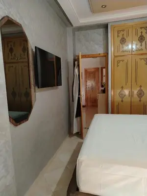 a bedroom with a bed and a tv on a wall at Appartement Confortable à Louer in Oulad Akkou