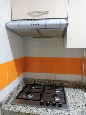 a stove top in a kitchen with orange and white at Appartement Confortable à Louer in Oulad Akkou