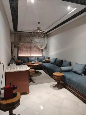 a living room with blue couches and a table at Appartement Confortable à Louer in Oulad Akkou