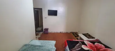 a room with two beds and a tv on the wall at faouzi walid in Er Rachidia