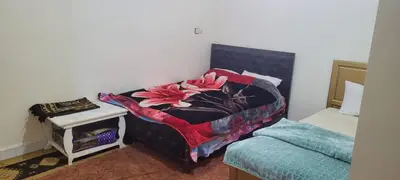 a bedroom with a bed with a blanket on it at faouzi walid in Er Rachidia