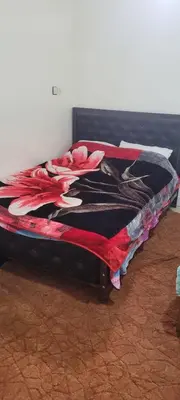 a bed with a red flower on top of it at faouzi walid in Er Rachidia
