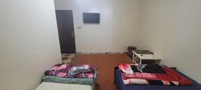 a room with two beds and a tv on the wall at faouzi walid in Er Rachidia
