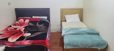a room with two beds and a bedskirts at faouzi walid in Er Rachidia