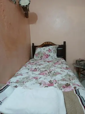 a bed with a floral comforter on it in a bedroom at house Merinides fes in Fès