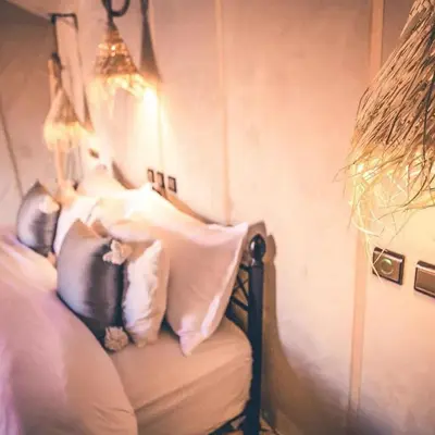 a bedroom with a bed with pillows on it at One Thousand and One Night Luxury Camp in Merzouga