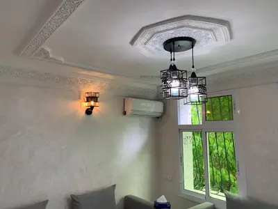 a living room with a chandelier and a window at chez saad in Fès