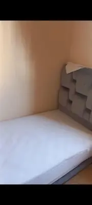 a small bed in a corner of a room at Apartamento en Rabat al lado del Mar in Oulad Akkou