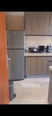 a kitchen with a refrigerator and wooden cabinets at Apartamento en Rabat al lado del Mar in Oulad Akkou