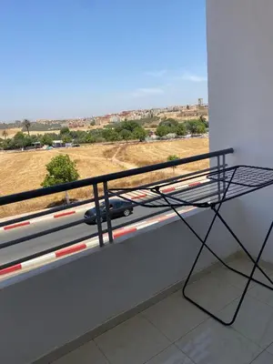 a balcony with a view of a car on the road at Meknès cosy près Médina in Meknès
