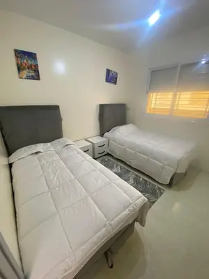 two beds in a room with white walls at Meknès cosy près Médina in Meknès