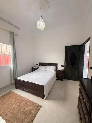 a bedroom with a large bed and a chandelier at Dar Sofilal à Marrakech
