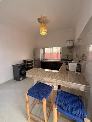 a kitchen with a table and two stools in a room at Dar Sofilal à Marrakech