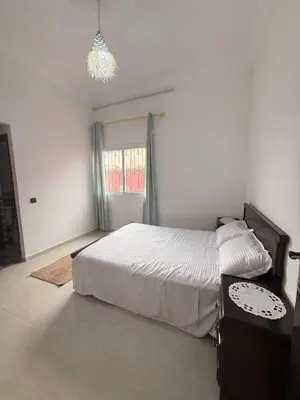 a bedroom with a bed and a table and a chandelier at Dar Sofilal à Marrakech