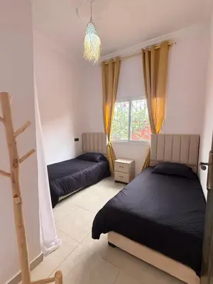 a bedroom with two beds and a chandelier at Dar Sofilal à Marrakech