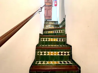 a set of stairs with green and gold tiles at Charming Riad Medina View 4 AC Bedrooms Panoramic Terrace Central Fez in Fès al Bali