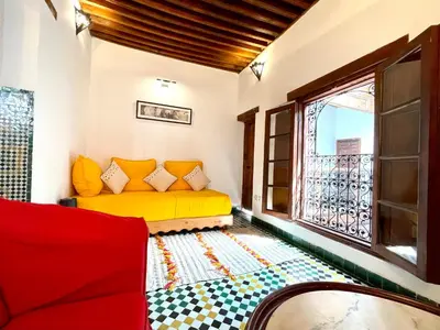 a living room with a yellow couch and a window at Charming Riad Medina View 4 AC Bedrooms Panoramic Terrace Central Fez in Fès al Bali