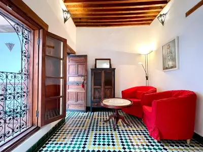 a living room with a red couch and a table at Charming Riad Medina View 4 AC Bedrooms Panoramic Terrace Central Fez in Fès al Bali