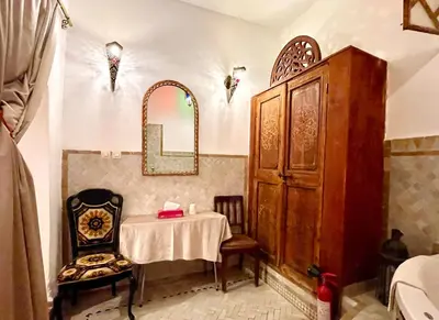 a dining room with a table and a mirror at Charming Riad Medina View 4 AC Bedrooms Panoramic Terrace Central Fez in Fès al Bali