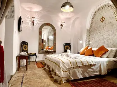 a bedroom with a large bed and a mirror at Charming Riad Medina View 4 AC Bedrooms Panoramic Terrace Central Fez in Fès al Bali