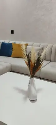 a white couch with a vase on a table at شقة مفروشة 3 غرف حمامين مطبخ وصالون in Oulad Akkou