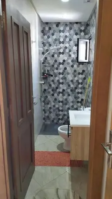 a bathroom with a shower and a toilet and a sink at شقة مفروشة 3 غرف حمامين مطبخ وصالون in Oulad Akkou