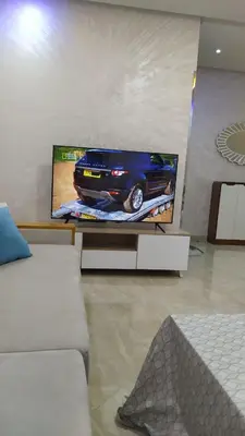 a room with a tv with a car on it at شقة مفروشة 3 غرف حمامين مطبخ وصالون in Oulad Akkou
