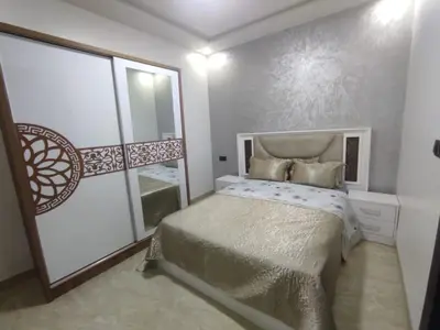 a small bedroom with a bed and a mirror at شقة مفروشة 3 غرف حمامين مطبخ وصالون in Oulad Akkou