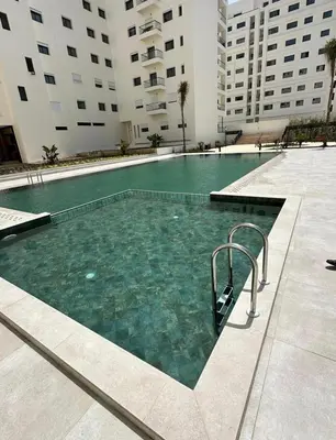 a swimming pool in the middle of a building at Schöne Ferienwohnung mit Pools in Oulad Akkou