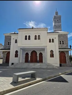 a large white building with a clock tower at Schöne Ferienwohnung mit Pools in Oulad Akkou