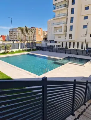 a swimming pool in front of a building at Schöne Ferienwohnung mit Pools in Oulad Akkou
