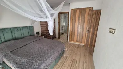 a bedroom with a bed and a wooden floor at Schöne Ferienwohnung mit Pools in Oulad Akkou