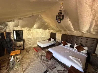 a bedroom with two beds in a tent at Fantastic desert camp in Oulad Akkou