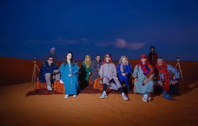 a group of people posing for a picture at night at Fantastic desert camp in Oulad Akkou